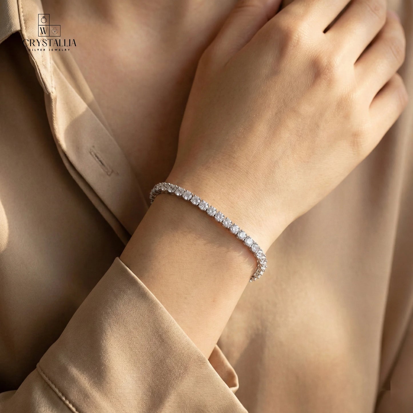 צמיד טניס אלגנטי בגימור כסוף עם שיבוץ אבנים נוצצות לכל אורכו, רוחב 3.5 מ"מ, של מותג קריסטליה