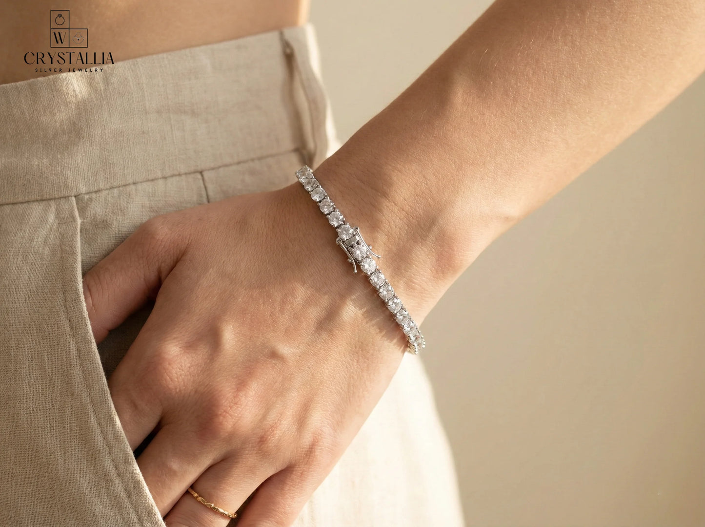 צמיד טניס אלגנטי בגימור כסוף עם שיבוץ אבנים נוצצות לכל אורכו, רוחב 3.5 מ"מ, דגם ZSI005-1 של מותג קריסטליה