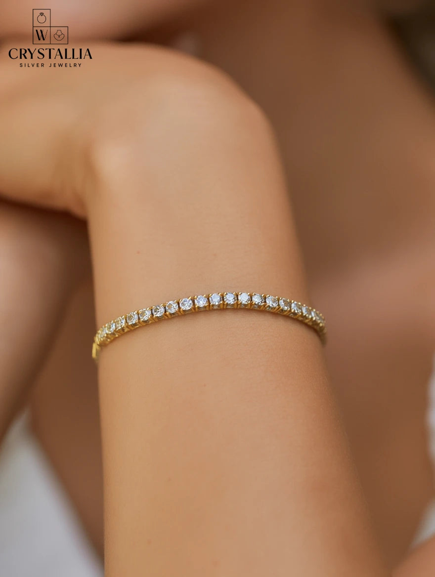 צמיד טניס מעוצב בגימור כסוף עם שיבוץ רציף של אבנים נוצצות, דגם ZSI055-3-2mm מבית מותג התכשיטים קריסטליה על רקע נקי.