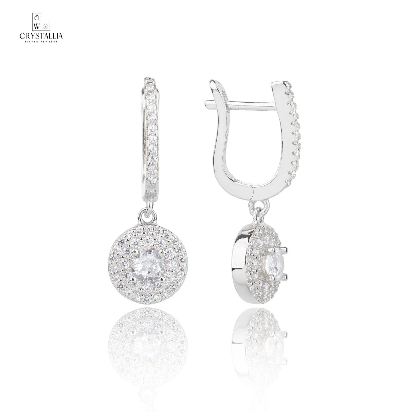 זוג עגילי כסף אמיתי 925 בסגנון נופל ומוארך, משובצים באבני זרקון מנצנצות לכל אורכם, צילום תקריב של תכשיטי קריסטליה.