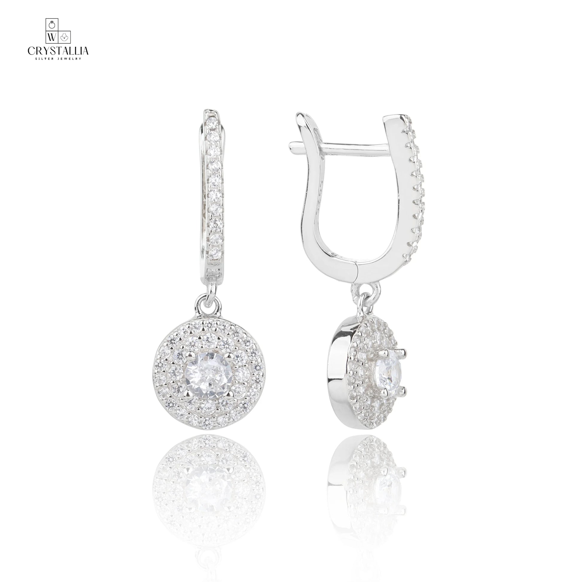זוג עגילי כסף אמיתי 925 בסגנון נופל ומוארך, משובצים באבני זרקון מנצנצות לכל אורכם, צילום תקריב של תכשיטי קריסטליה.
