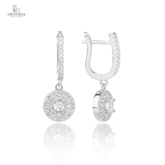 זוג עגילי כסף אמיתי 925 בסגנון נופל ומוארך, משובצים באבני זרקון מנצנצות לכל אורכם, צילום תקריב של תכשיטי קריסטליה.